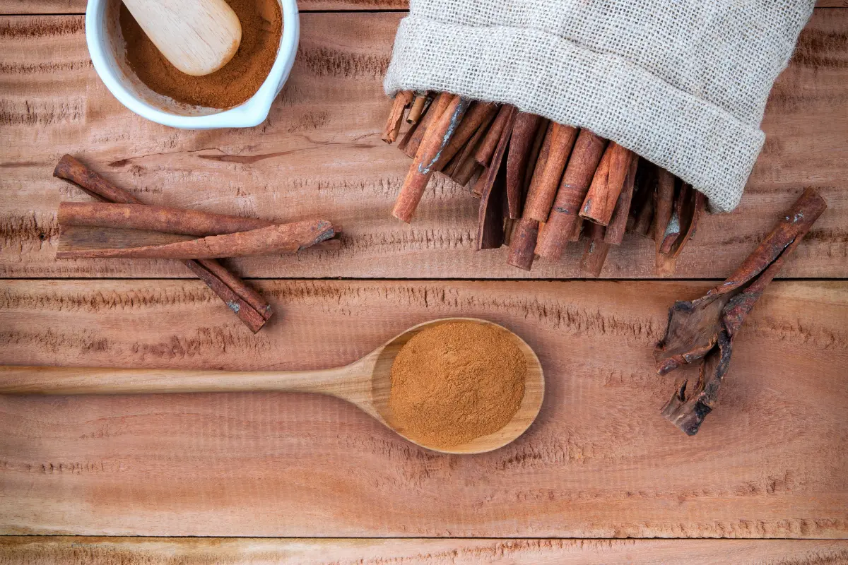 Cinnamon sticks and ground cinnamon on a wooden surface, symbolizing health benefits.