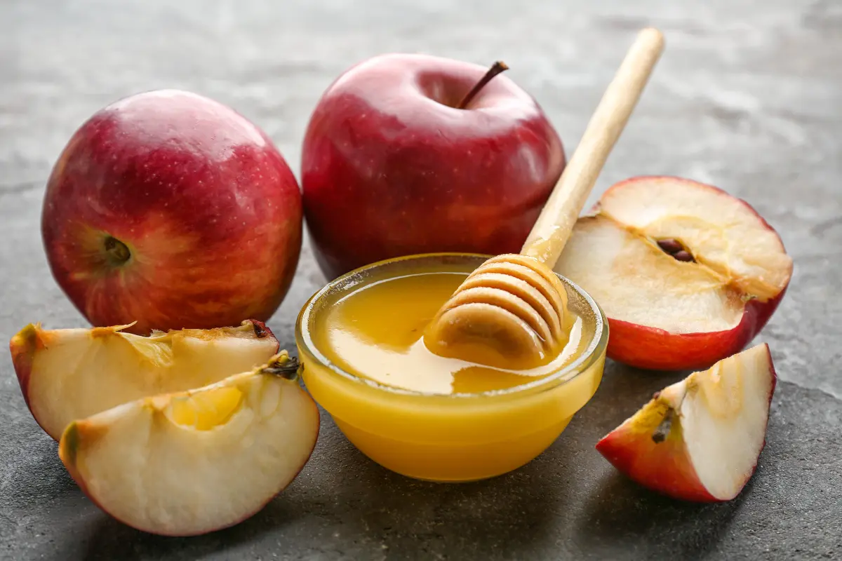 A chef adding spices to a pot of simmering applesauce.