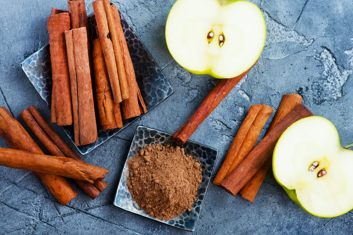 Sliced apples and cinnamon sticks representing health benefits.