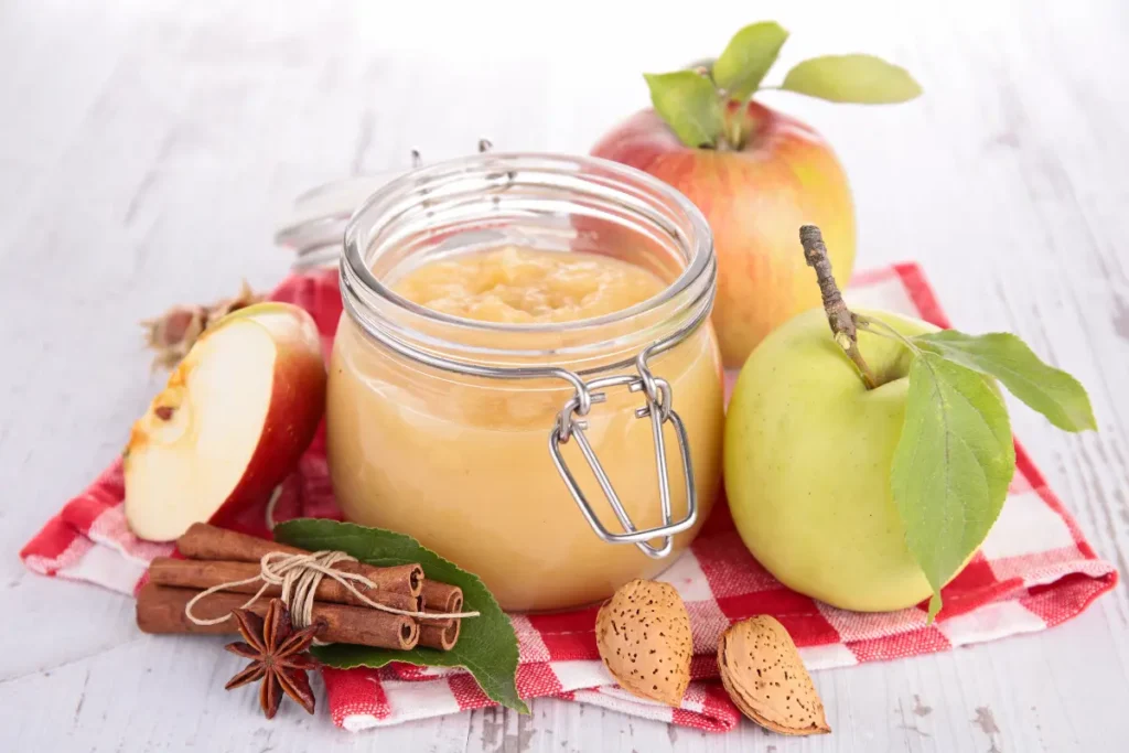 Cozy scene with cinnamon applesauce, warm spices, and apples.